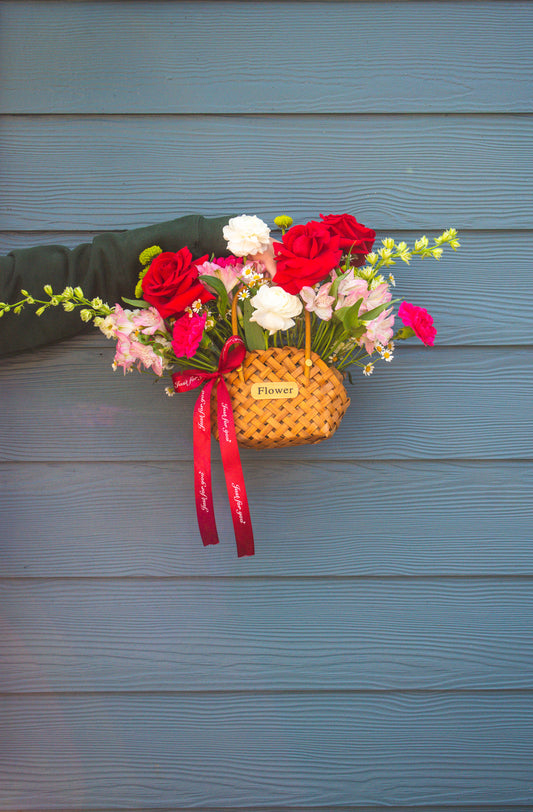 "La Flor" flower arrangement in a wicker purse